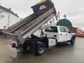 A 2021 Ford F-550 dump truck with its bed raised for unloading materials