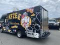 A 2011 Ford Utilimaster Food Truck decorated with colorful graphics featuring a chicken holding food and text promoting catering services