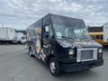 A 2011 Ford Utilimaster food truck with a black exterior featuring vibrant graphics and signage