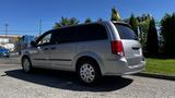 A silver 2016 Dodge Grand Caravan parked with its side view visible showcasing its sleek design and alloy wheels