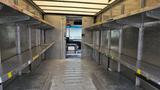 Interior of a 2006 Ford Econoline cargo van featuring metal shelving on both sides and an open back entrance with space for transporting items