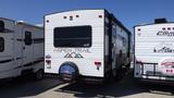 A 2022 Aspen Trail travel trailer featuring a white exterior with black accents and the name "Aspen Trail" displayed on the rear