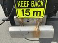 A 2010 Ford F-550 with a rectangular metallic bumper featuring a warning sign that reads KEEP BACK 15 m