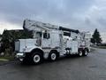 A white 2011 Western Star Trucks 4900 utility truck equipped with an aerial lift and storage compartments on the side