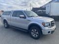 A silver 2014 Ford F-150 with a crew cab and a truck bed cap is parked with its front angled towards the viewer