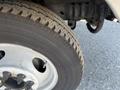 Close-up of a tire and wheel of a 2011 Ford Econoline showing tread pattern and silver alloy rim