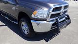 A 2014 RAM 3500 pickup truck with a chrome front grille and bumper featuring a black bull bar attached to the front