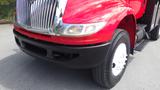 A red 2010 International 4400 truck with a chrome grille and large headlights parked on a surface with visible tires and a black bumper