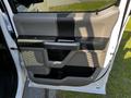 Interior door panel of a 2017 Ford F-150 featuring a combination of gray and black materials with integrated handles and controls