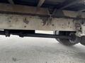 A close-up of the underside of a 2007 International 4300 showing the drive shaft connected to the rear axle and the vehicle frame with visible rust and wear marks