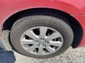 A close-up of a 2007 Toyota Camry Hybrid's wheel showcasing a gray alloy rim and a slightly worn tire tread