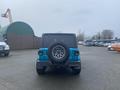 A blue 2020 Jeep Wrangler with a spare tire mounted on the back and a rugged tire design