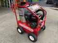 A red Magnum 4000 Hot Water Pressure Washer with a large cylindrical tank a black engine and wheels for mobility