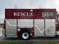A red 1994 Freightliner FL80 rescue vehicle with silver paneling and the word RESCUE displayed prominently on its side