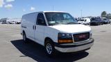 A white 2012 GMC Savana van with a black grille and silver bumpers positioned at an angle showing the front and side profiles