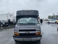 A 2017 Chevrolet Express van with a high roof and front grille visible, parked with rain on the windshield