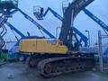 A yellow 2014 John Deere 350G excavator with a large arm and tracks positioned on a construction site