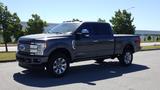 A 2017 Ford F-350 Super Duty truck in dark gray with chrome accents and large wheels parked on a street