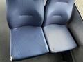 A blue upholstered seat with some visible wear and tear