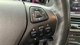 Close-up of the steering wheel controls in a 2013 Lincoln MKT featuring buttons for navigation volume and call functions