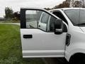 A white 2020 Ford F-350 SD with a partially open driver's side door showcasing the interior features and a side mirror