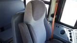 A close-up of a gray upholstered driver's seat in a 2014 International 3000 bus featuring a high back and seatbelt