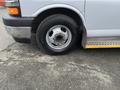 A 2017 Chevrolet Express van wheel with a silver rim and a black tire positioned on a paved surface