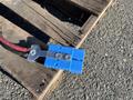 A blue electrical connector attached to a red cable on a wooden pallet