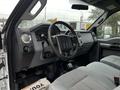 Interior of a 2014 Ford F-550 featuring a steering wheel dashboard controls and gray upholstery on the seats