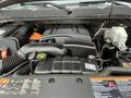 The engine compartment of a 2013 Chevrolet Silverado Hybrid showing components including an orange high-voltage cable and various engine parts