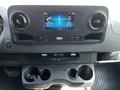 Interior dashboard of a 2022 Mercedes-Benz Sprinter featuring a central touchscreen display and dual cup holders below
