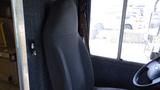 A 2011 Ford Econoline driver's seat with gray fabric upholstery positioned next to a steering wheel in a vehicle cabin