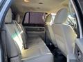 Interior of a 2013 Ford Expedition showing beige leather rear seats with a spacious layout and a simple dashboard design
