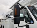 A 2007 International 4200 bucket truck with a raised aerial work platform and a prominent side mirror