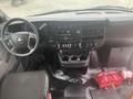 Interior view of a 2017 Chevrolet Express showing the dashboard control panel and center console with cup holders and various buttons