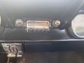 The dashboard of a 1966 Ford Mustang featuring a vintage radio and knobs with a chrome finish