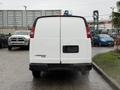 A 2009 Chevrolet Express van viewed from the rear showcasing its white exterior and logo on the back door