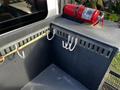 A 2013 International DuraStar 4300 with a mounted fire extinguisher and several hooks along a metal panel in the cargo area