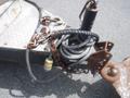 Close-up of a 2010 Forest River Enclosed trailer hitch featuring a coupling mechanism chains and a hydraulic line