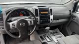 Interior view of a 2016 Nissan Frontier showing the steering wheel dashboard gear shift and center console