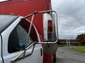A 2008 Ford F-750 truck showing the side mirror and a red light attached to the body of a trailer