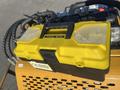 A yellow tool box with a black bottom labeled TOOL BOX sits on the top of a mini skid steer's control panel