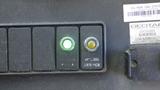 A 2011 Ford Econoline dashboard with two buttons one green and one yellow labeled hybrid and service