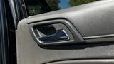 Close-up of the door handle on a 2018 Chevrolet Tahoe showing textured gray interior and polished metal accents