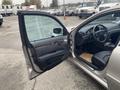 A 2007 Mercedes-Benz E-Class with the driver's side door open revealing a black leather interior and wood panel accents