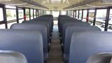 Interior view of a 2014 International 3000 school bus featuring rows of blue upholstered seats and a central aisle