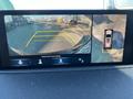 A 2023 Acura MDX displayed on a rearview camera screen showing the vehicle's surroundings with guidelines for parking