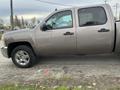 A 2013 Chevrolet Silverado Hybrid with a brown exterior and silver wheels parked with its driver side visible