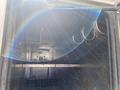 Interior view of a 2010 Ford F-550 showing metal hooks and a metallic structure inside a compartment with a light flare effect