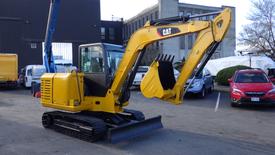 A yellow 2019 CAT 306E2 mini excavator with a front bucket and track wheels positioned for operation